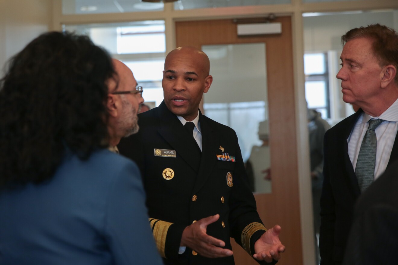 U.S. Surgeon General Vice Adm. Jerome M. Adams (center) speaks with Gov. Ned Lamont and other officials about COVID-19 at the Connecticut Department of Public Health Laboratory in Rocky Hill, Monday, March 2, 2020.